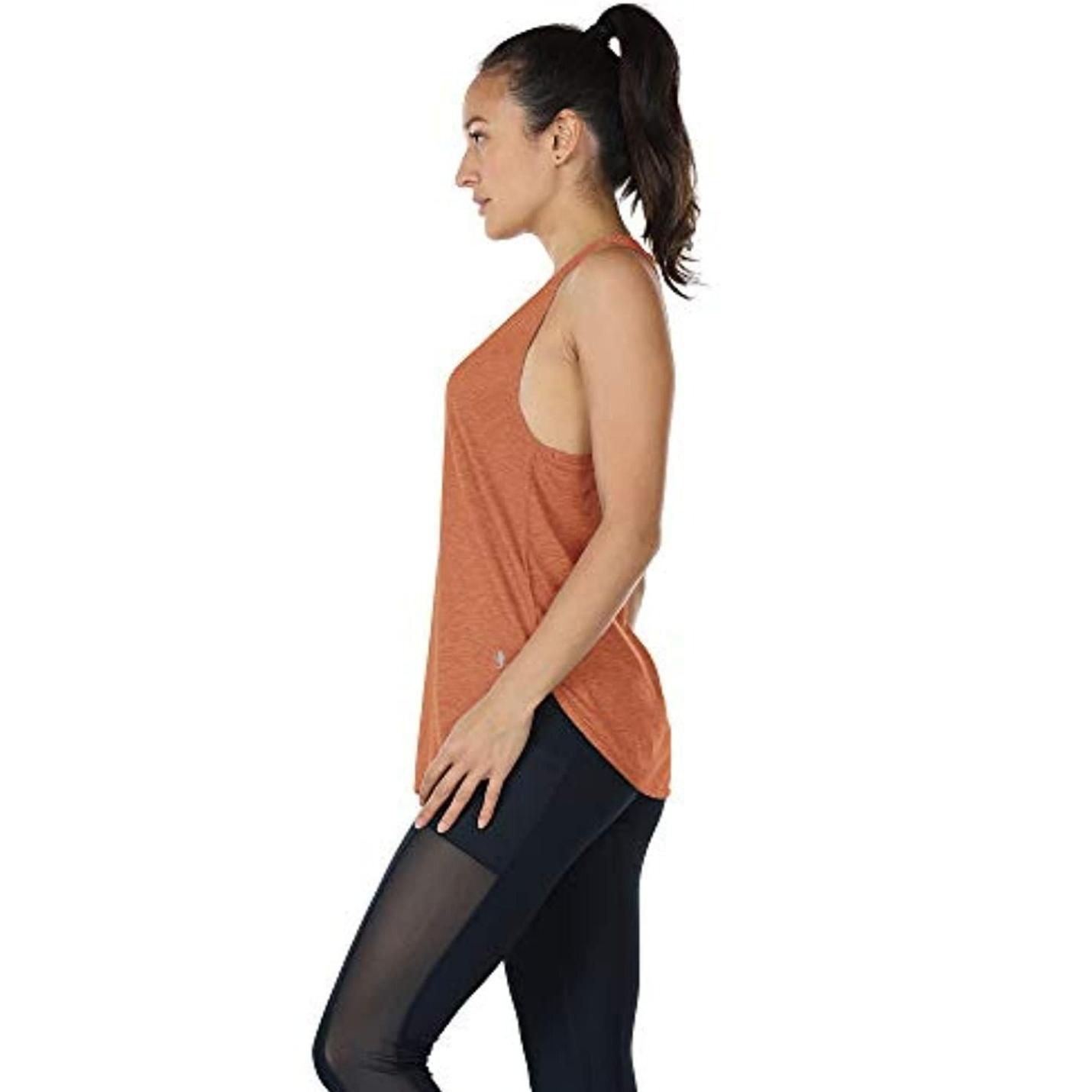 Zijaanzicht van een vrouw in oranje Ontdek de stijlvolle en functionele dames tanktop, sporttop racerback en zwarte legging, met haar haar in een paardenstaart, naar links kijkend.