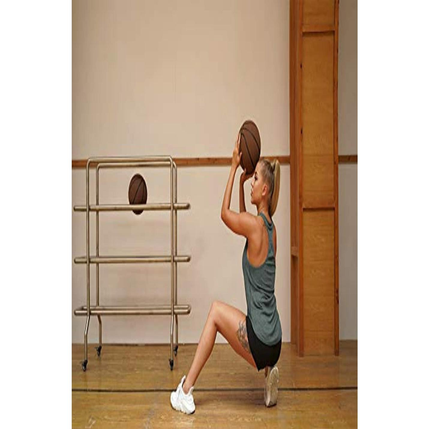 Een vrouw in een sportschool die zich voorbereidt op het schieten van een basketbal, gekleed in de Ontdek de stijlvolle en functionele dames tanktop sporttop racerback voor maximale bewegingsvrijheid, met een ballenrek op de achtergrond.