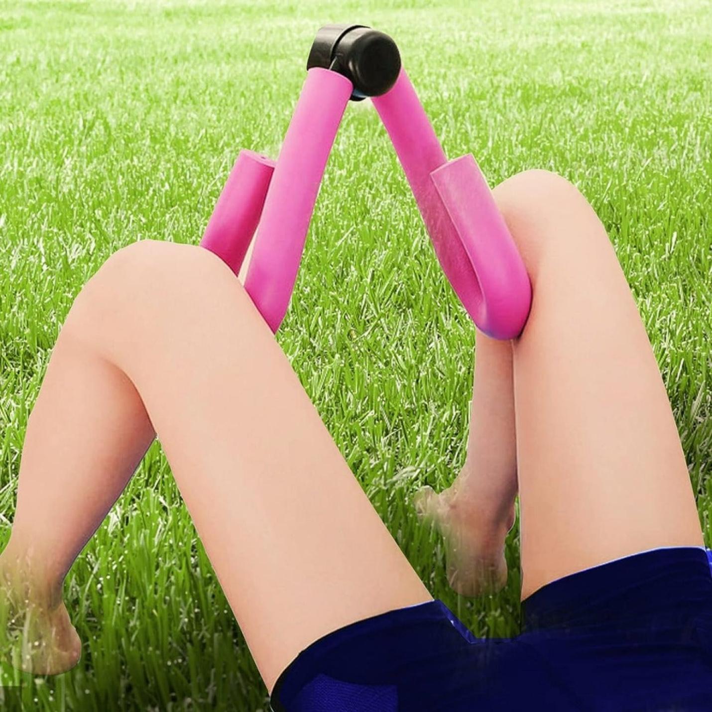 Persoon die met de benen omhoog op het gras ligt en een Dikke Dien vasthoudt? Verander ze in sterke en slanke benen met onze dijbeen trainer!