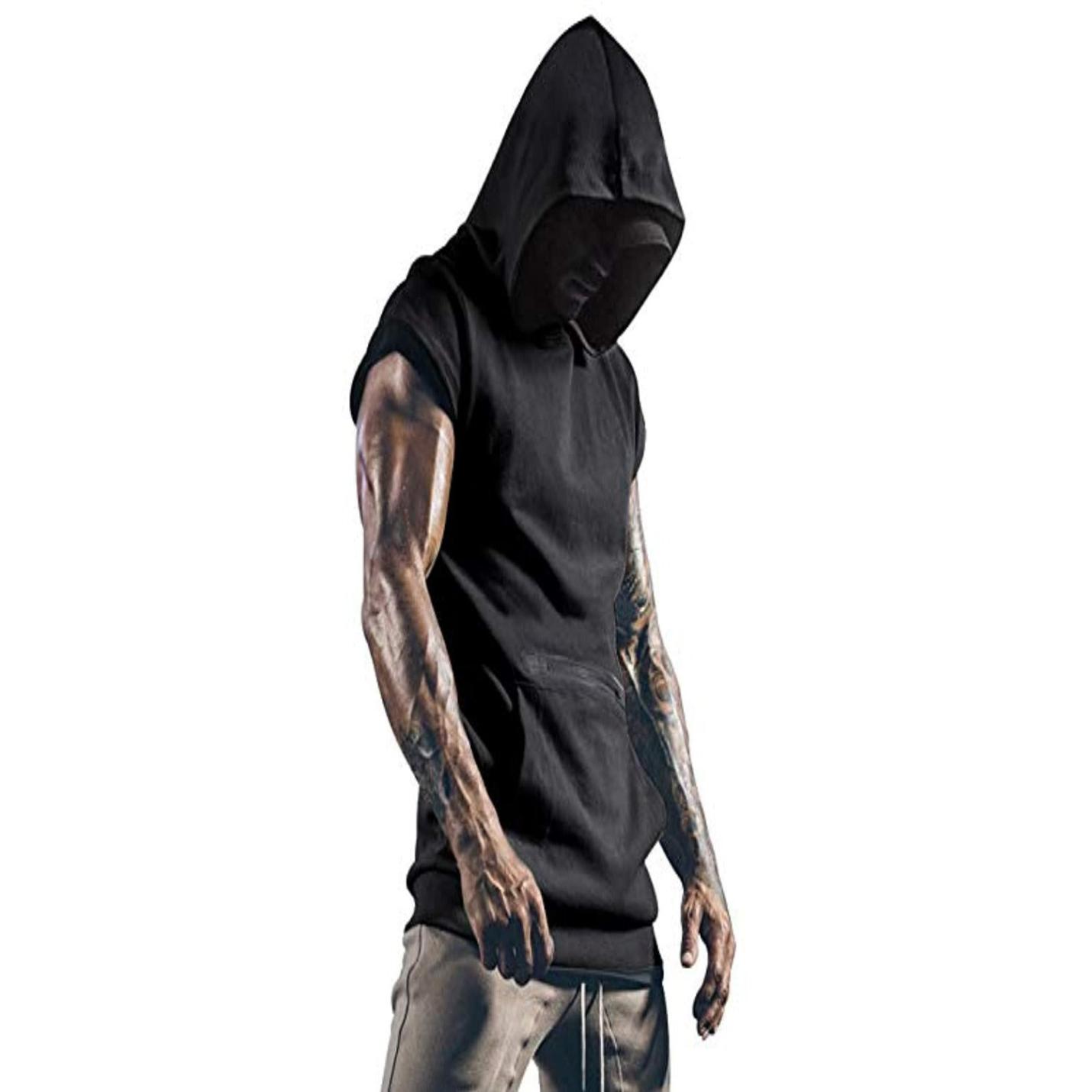 Een gespierde persoon, gekleed in een Gym-tanktop voor heren en een grijze broek, met getatoeëerde armen, staat met gebogen hoofd en gevouwen handen.