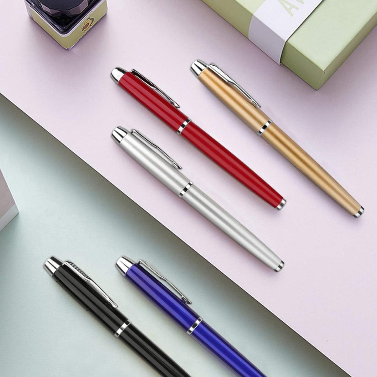 Zes Laat een blijvende indruk achter met deze elegante en hoogwaardige rollerbalpennen in de kleuren zilver, rood, goud en blauw diagonaal gerangschikt op een pastelroze achtergrond.