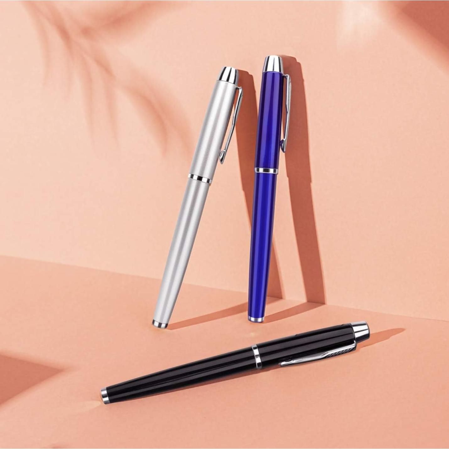 Drie elegante rollerbalpen diagonaal geplaatst op een perzikkleurige achtergrond.