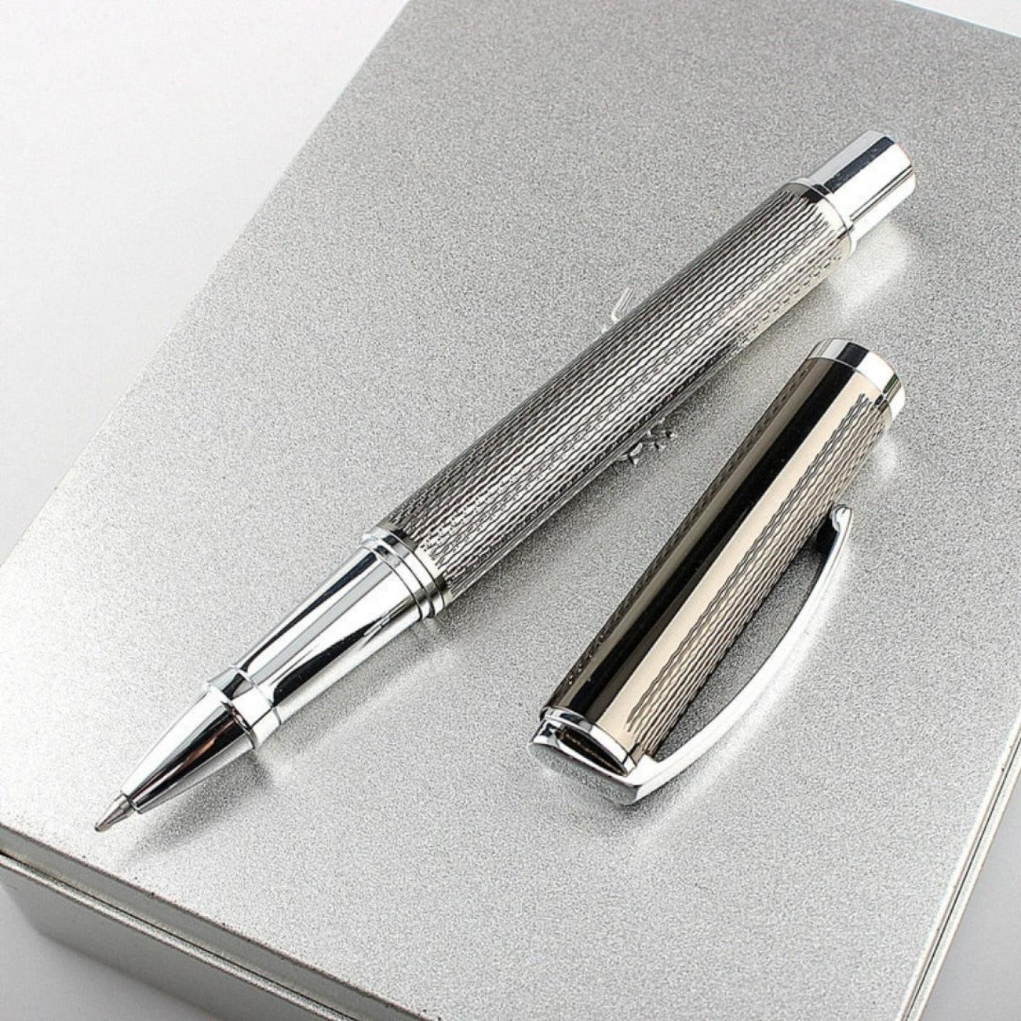 Schrijf in stijl met de Schrijf in stijl met de luxe kantoorpen, het perfecte schrijfinstrument voor elke professionele omgeving van zilver met een getextureerde patroon liggend op een notitieboek met de doperaf.