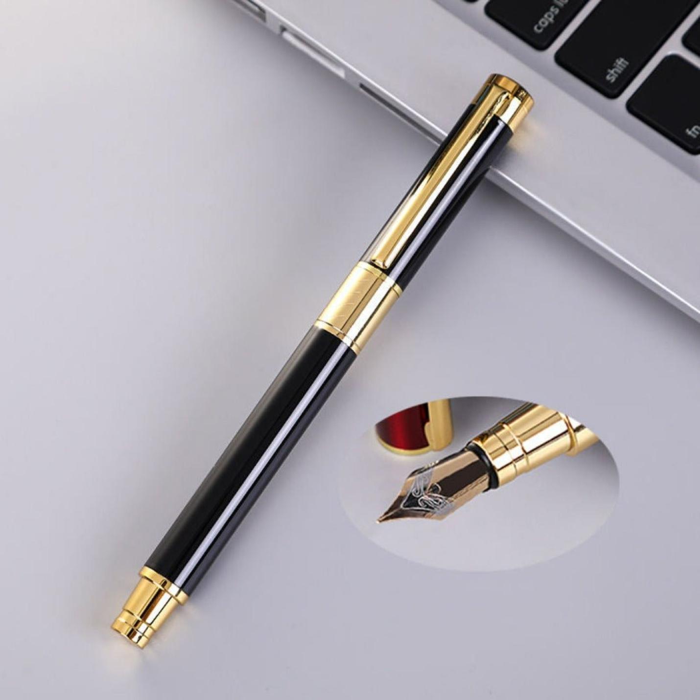 Een luxe zwarte en gouden Schrijf in stijl met onze luxueuze marmeren vulpen met iridium punt, ligt op een bureau naast een laptop, met de dop verwijderd om de nib te begrijpen.