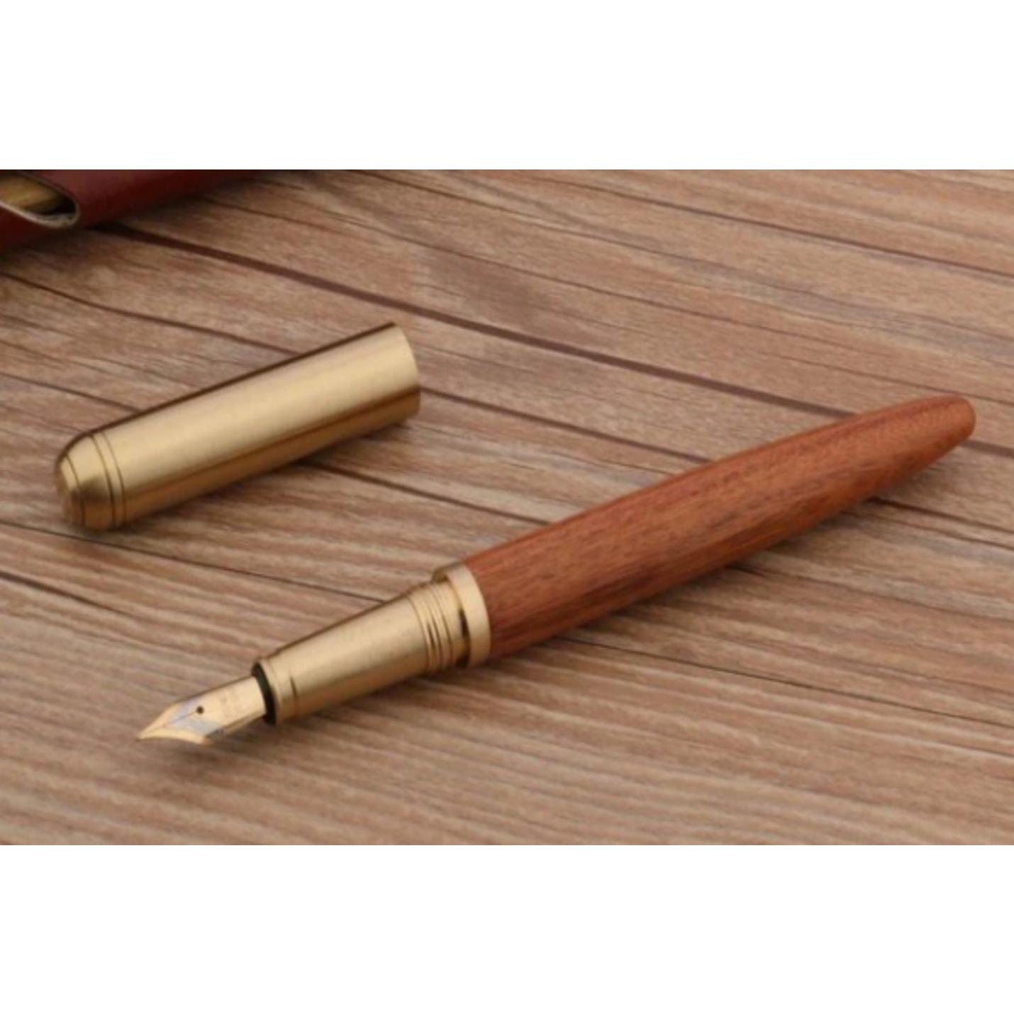 Schrijf in stijl met onze unieke Schrijf in stijl met onze unieke houten en koperen pen met F-nib op een houten tafel.