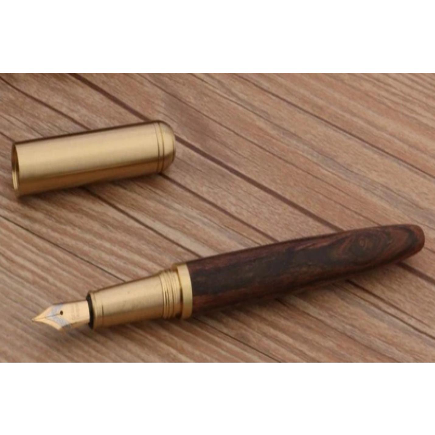 Een duurzame Schrijf in stijl met onze unieke houten en koperen pen met een houten vat en koperen dop liggend op een houten oppervlak.