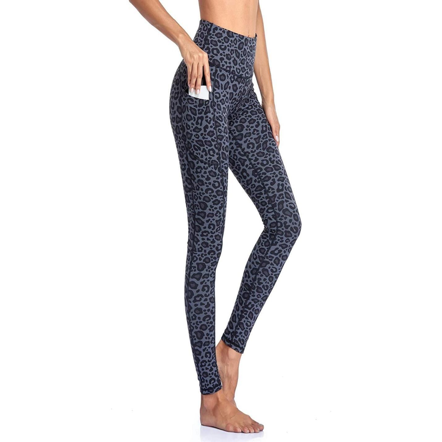 Vrouw, gekleed in grijze legging met hoge taille met luipaardprint en buikcontrole, staat op blote voeten en plaatst een smartphone in de zijzak.
Productnaam: Hoge taille legging dames - Comfortabele, ondoorzichtige sportlegging voor sport en fitness