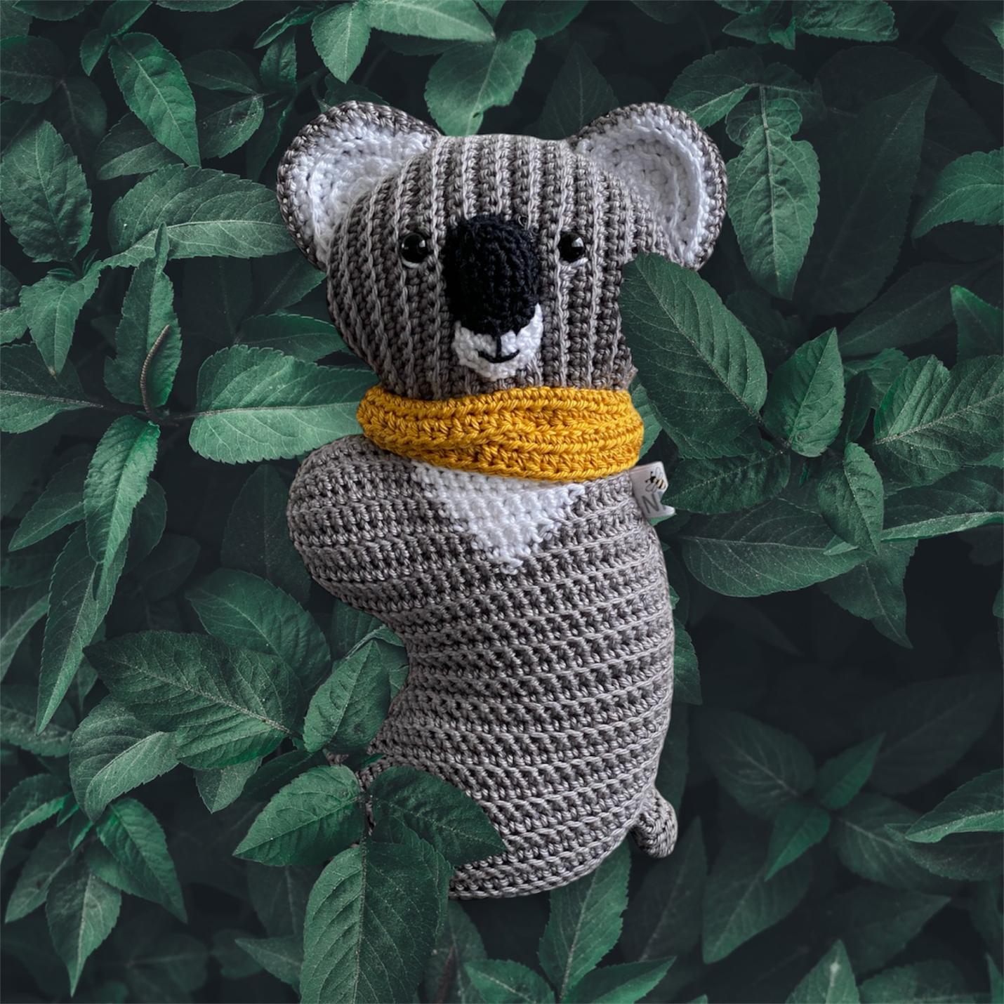 Gehaakte knuffel Ribblz Koala grijs met okergele sjaal voorkant in eigen habitat