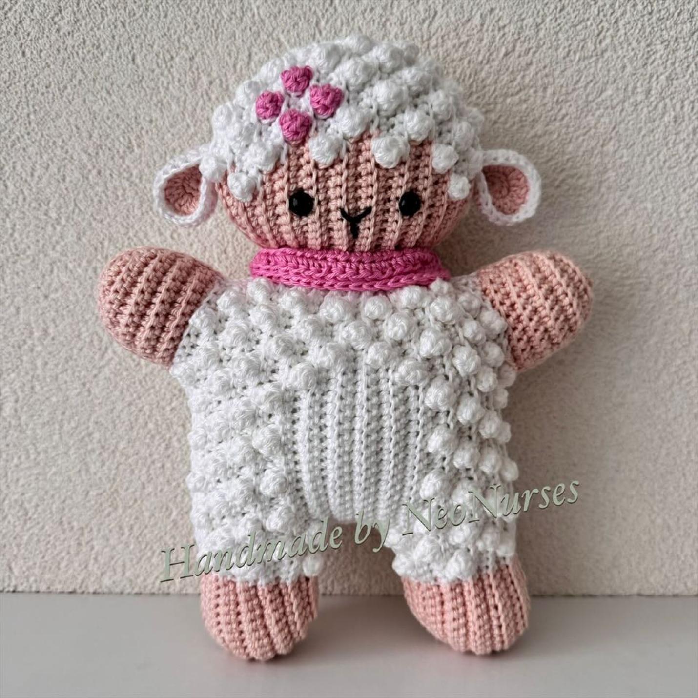 Ribblz Lammetje Wit platte gehaakte lammetje wit met lever kleur voetjes, handjes en onderkant gezichtje en roze sjaal om en roze bloem op hoofd