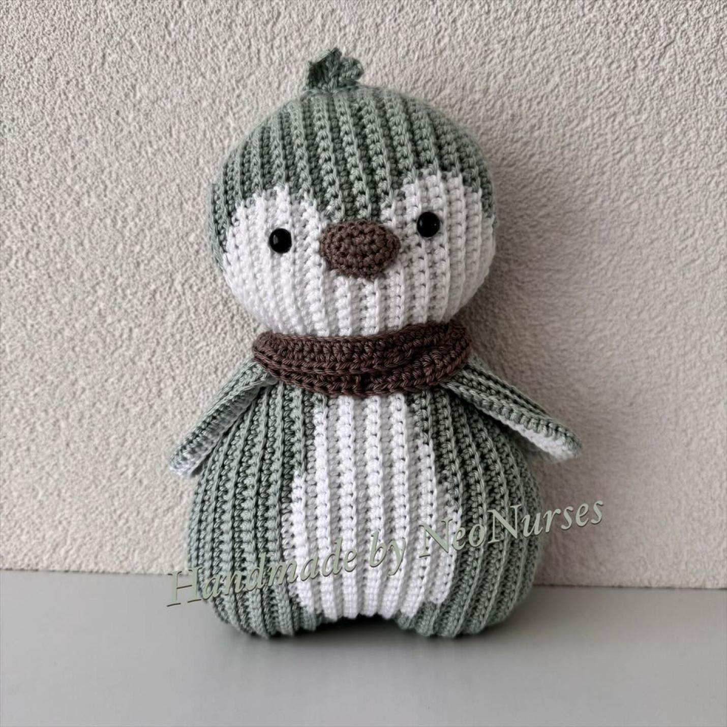 Ribblz Pinguïn groen is gehaakte platte pinguïn met wit op midden buik en rond ogen heeft een bruine sjaal en neus en kraal oogjes