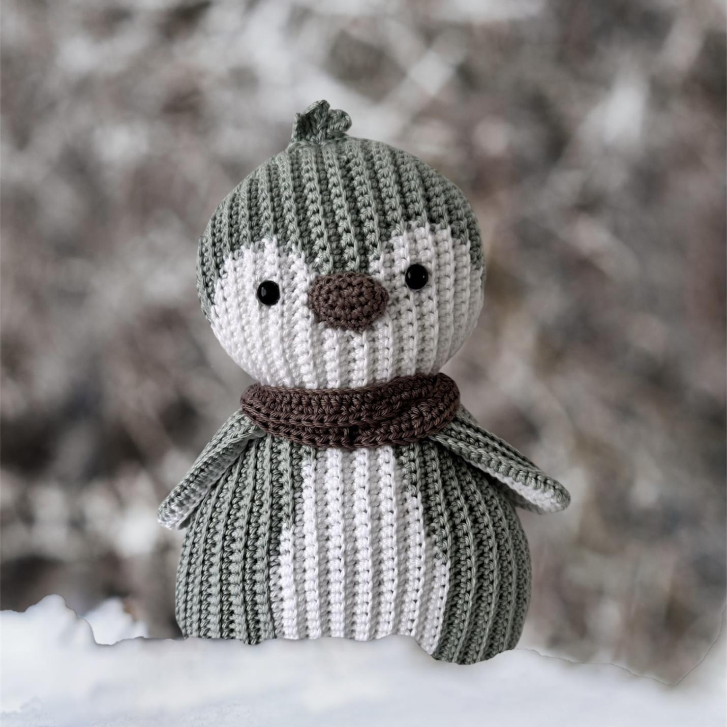 Gehaakte knuffel Ribblz pinguïn resedagroen-wit voorkant staat in de sneeuw