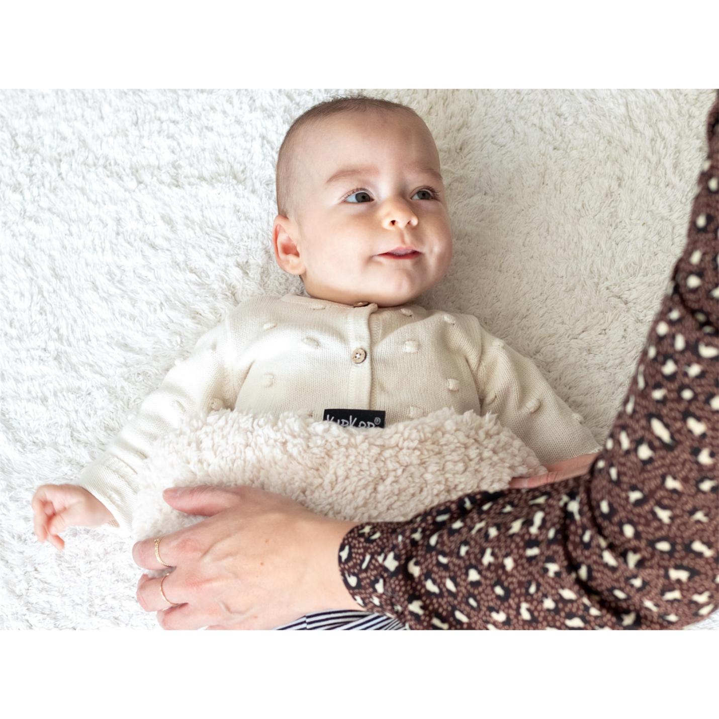 KipKep-woller- Teddy Sand-op buikje baby met hand moeder