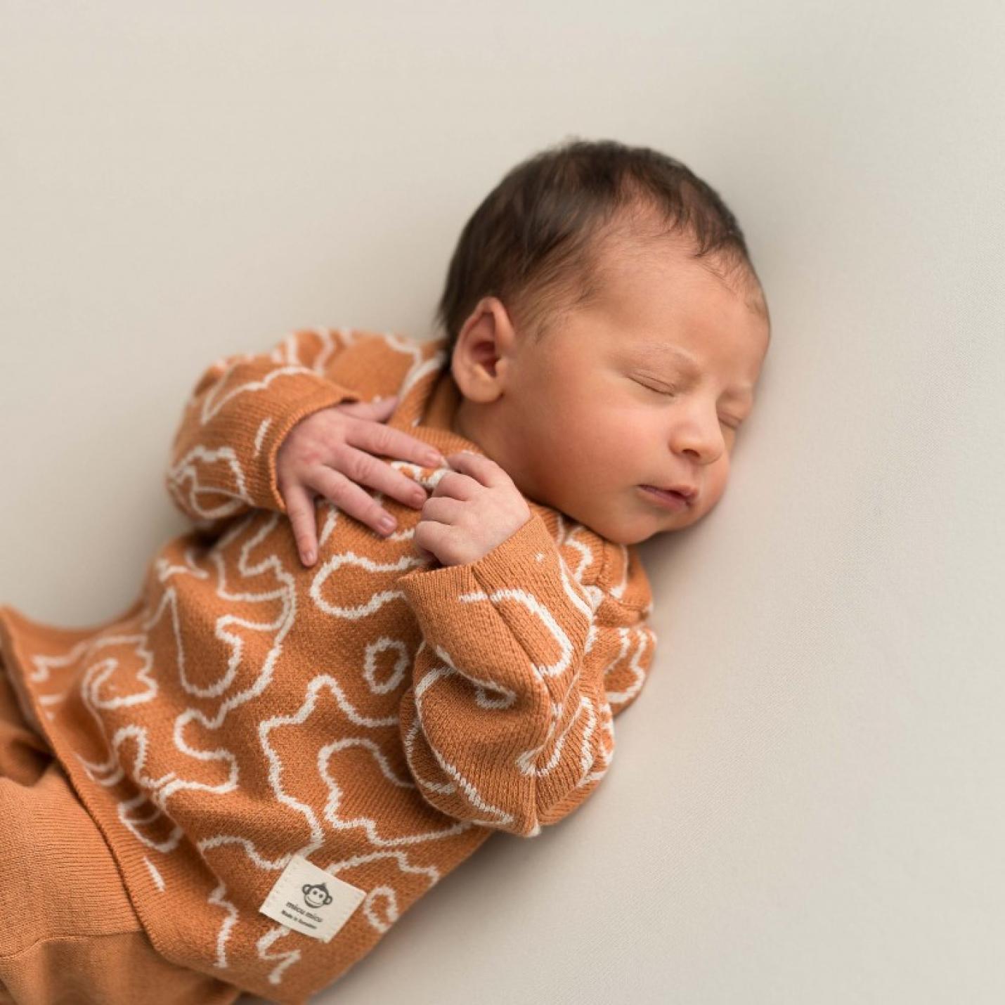 Kledingset Newborn Roest is een babykledingsetje in de kleur roest met een shirtje met witte vlekken en roestkleur en broekje met voeten effen roestkleur