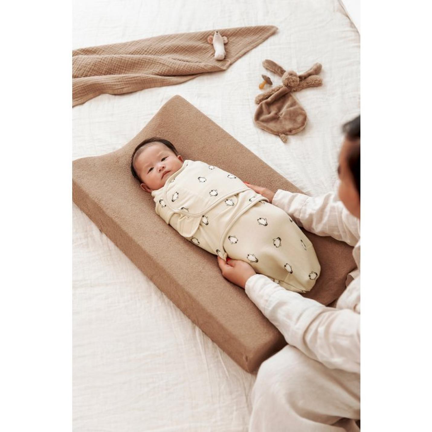 Meyco-Baby-Swaddle-inbakerdoek-1-pack-pinguïn-softsand-baby op aankleedkussen