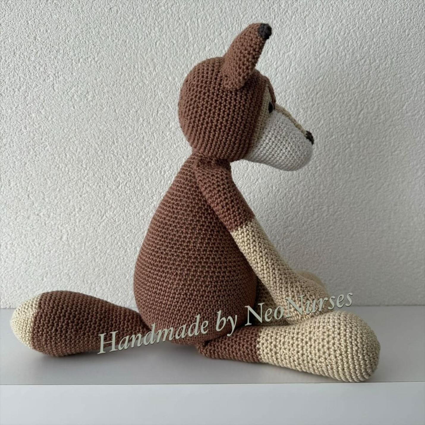 Zijaanzicht gehaakte knuffel Wolf Wouter is gehaakte wolf bruin met deel gezicht, voeten, handen in beige.