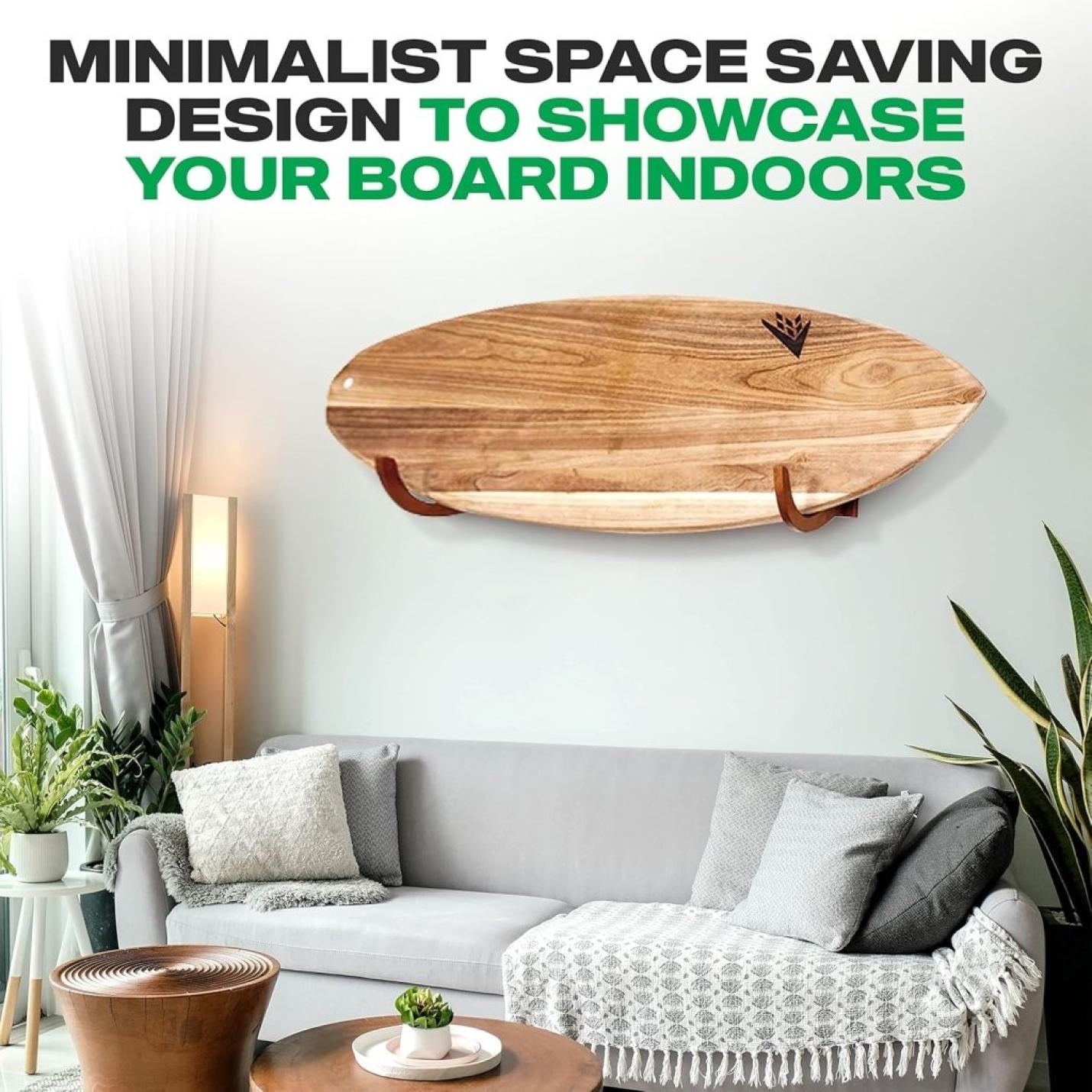 Een minimalistische woonkamer met een bamboe surfplank van "Jouw surfplank verdient een stijlvolle display! 🏄‍♂️" elegant gemonteerd aan de muur boven een grijze bank, planten en salontafel. Tekst benadrukt ruimtebesparend ontwerp en boardbescherming voor binnendisplay.