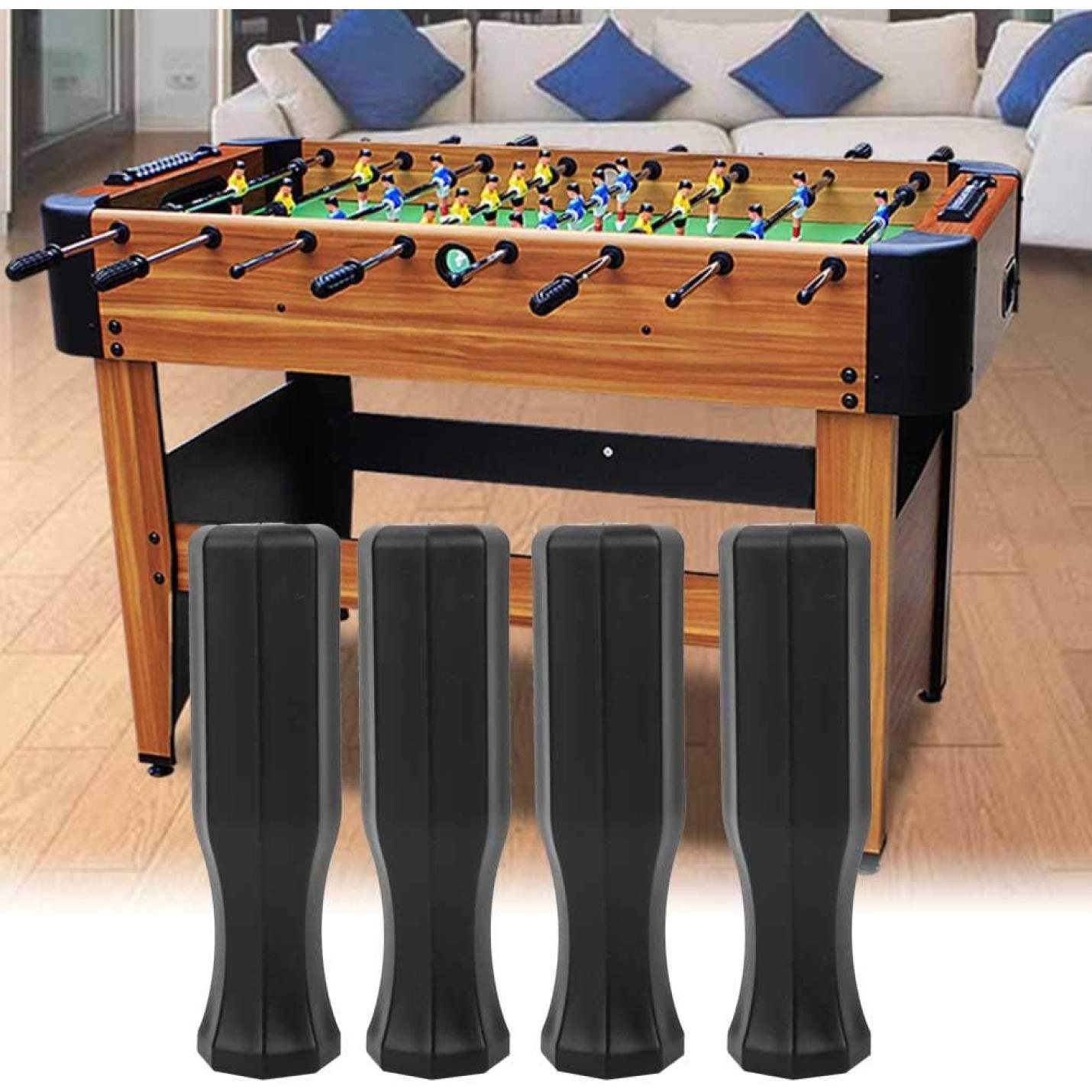 Een tafelvoetbaltafel met een houten frame en zwart beslag complementeert een woonkamer met een beige vloer en een bank met blauwe kussens. Het beschikt over vier afneembare "⚽ Meer grip, meer controle – speel tafelvoetbal als een pro met deze tafelvoetbal handgrepen!" biedt ergonomische grip voor stijlvolle, comfortabele gameplay.